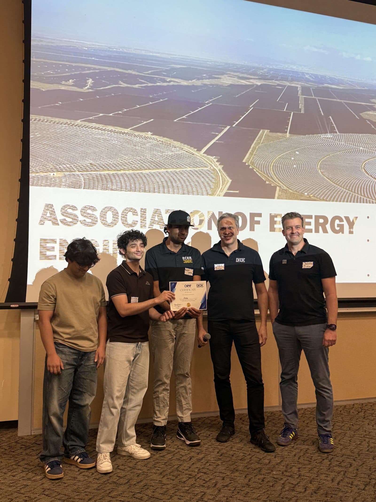 A team receives a certificate on stage from two organizers at the closing awards.