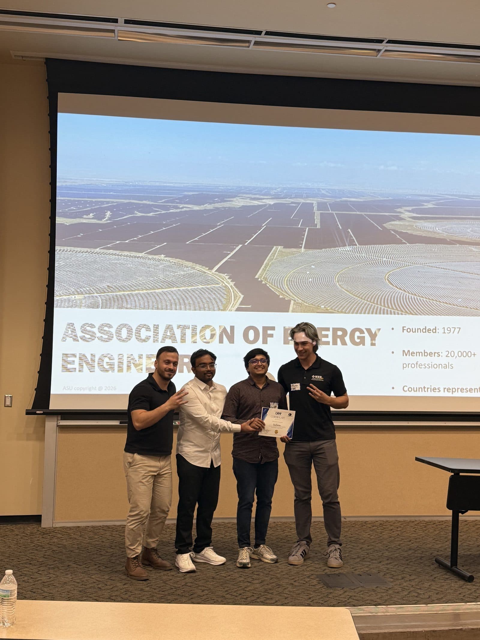 A winning team stands with an organizer holding their certificate after the software track results.